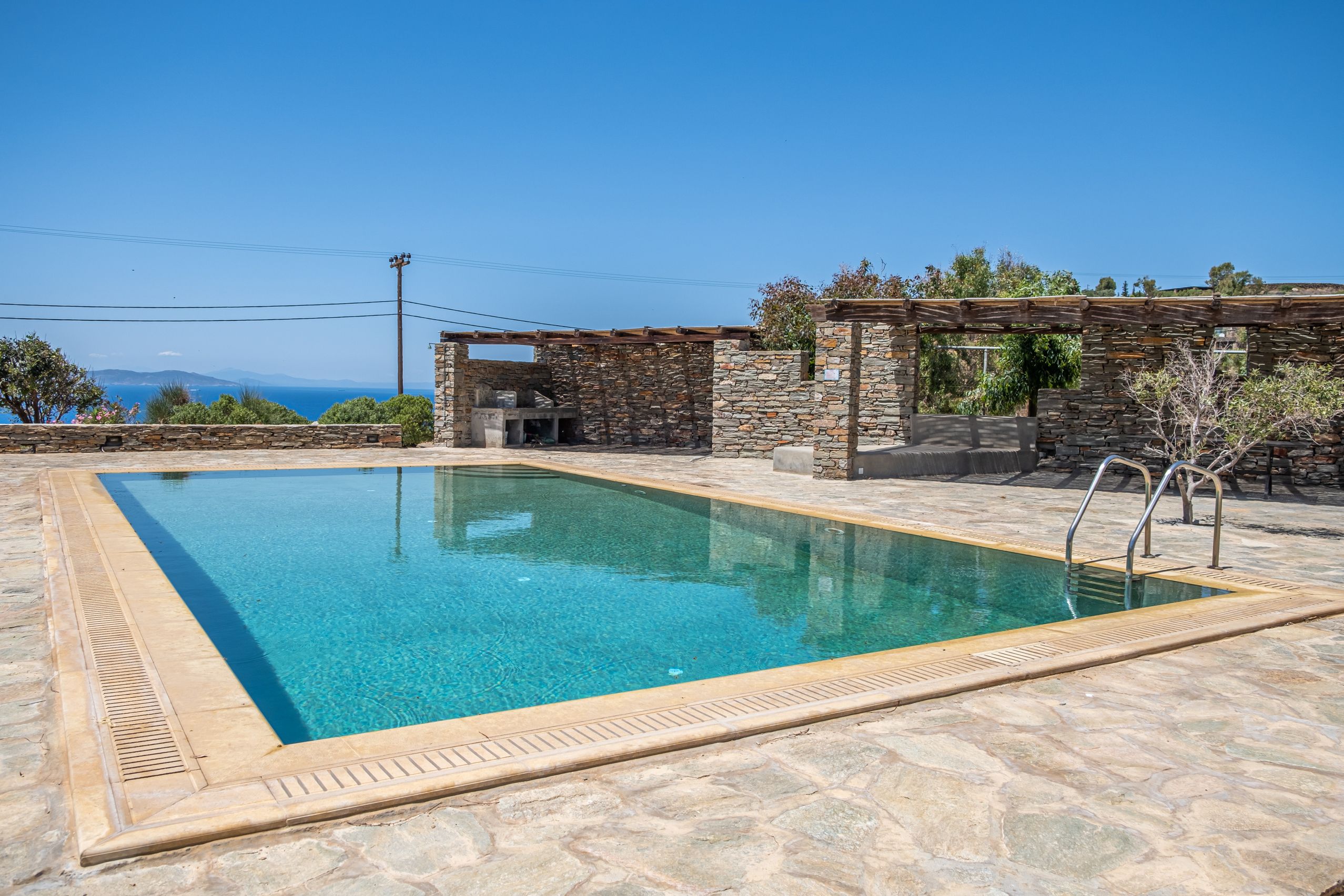 Built-in stone barbecue and outdoor dining area on a shaded terrace