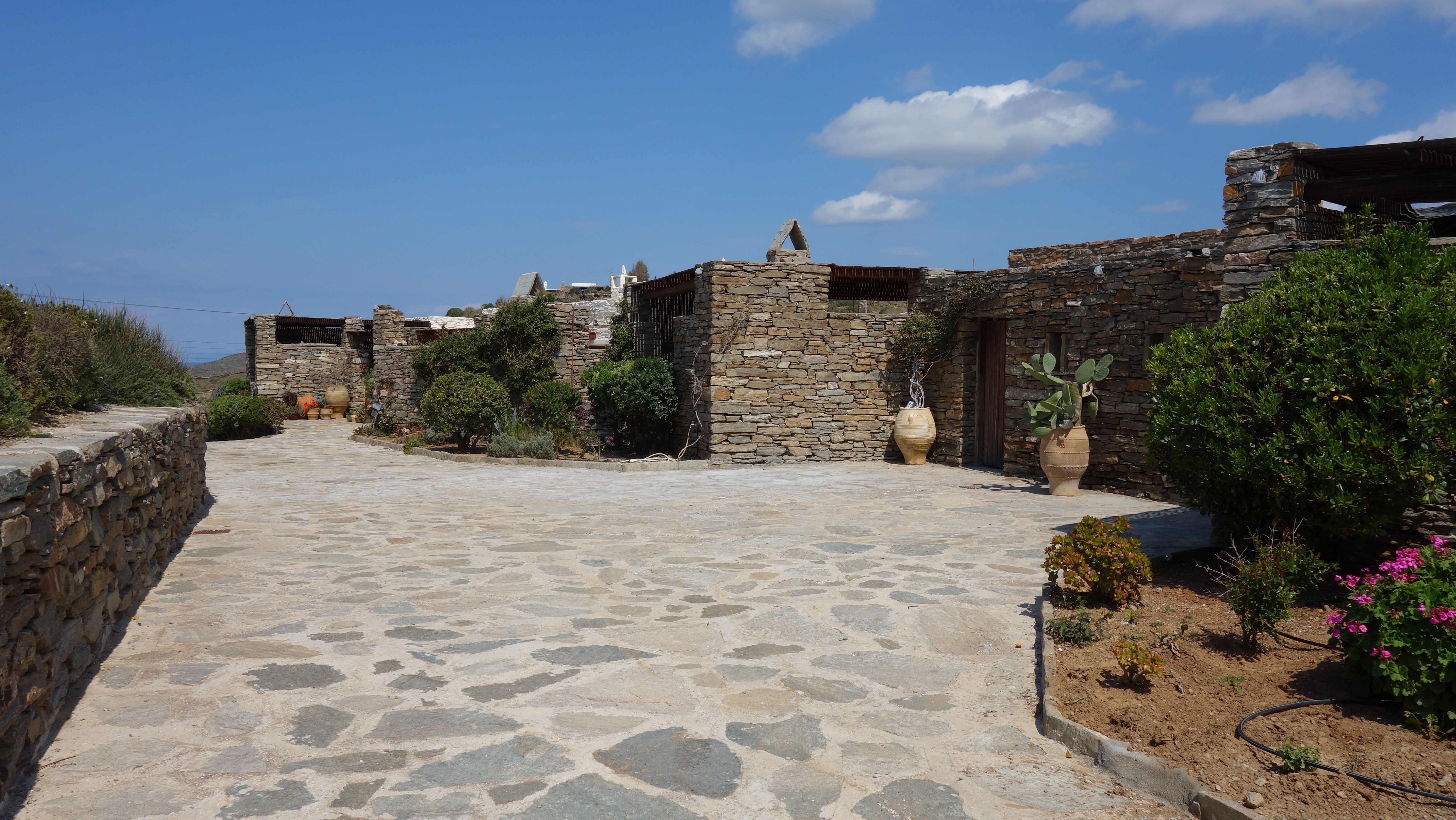 The approach road to Zephyros Stone Villa, lined with stone walls and olive trees