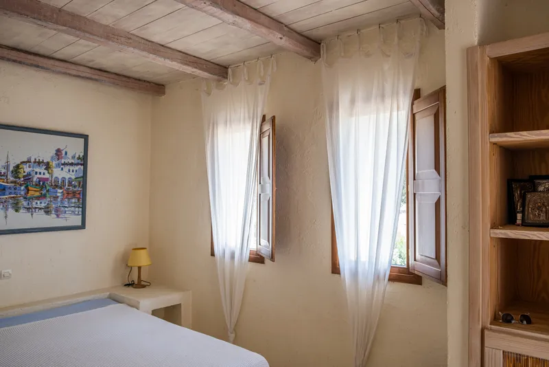 Master bedroom sitting area with soft linen and warm lighting