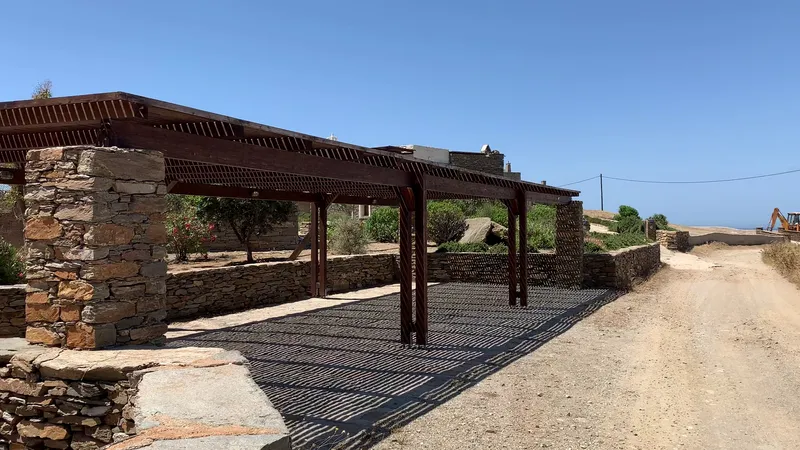 Covered parking area with timber pergola and stone pillars