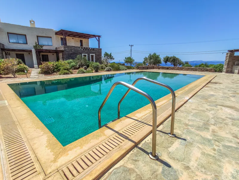 Pool at midday with clear blue water reflecting the Aegean sky